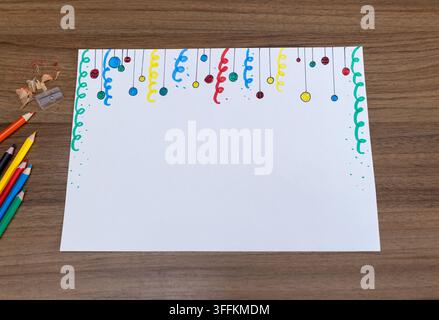 Colorful Christmas drawing on white paper with pencils and copy space on wooden table Stock Photo