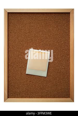 Blank instant photo pinned to a cork notice board in a simple wooden frame, with generous copy space for memories, notes or creative concepts Stock Photo