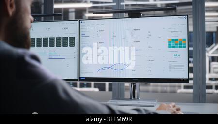 Cybersecurity Specialist Monitors Data Center After Cyber Attack Alert, Analyzing Dashboards on Dual Screens While Responding to Threats, Protecting S Stock Photo