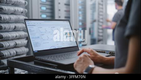 Female Data Center IT Engineer Responds to Critical Server Overheating Alert Through Linux CLI, Monitoring System Health and Entering Emergency Comman Stock Photo