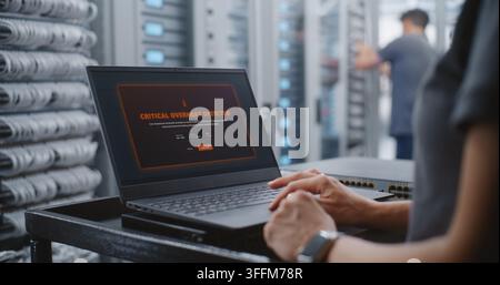 Female Data Center IT Engineer Responds to Critical Server Overheating Alert Through Linux CLI, Monitoring System Health and Entering Emergency Comman Stock Photo