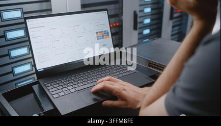 Male IT Specialist Responds To Cyber Attack Alert Using Linux Command Line, Reviewing Telemetry and Performing Emergency Recovery Actions During Criti Stock Photo