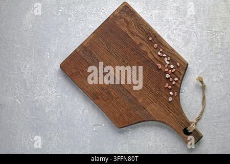 Rustic Wooden Cutting Board with Himalayan Salt on Grey Concrete Stock Photo