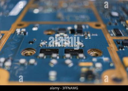 Image of a blue electronic circuit board featuring diodes, capacitors, transistors, and resistors, for use in technology devices. Stock Photo