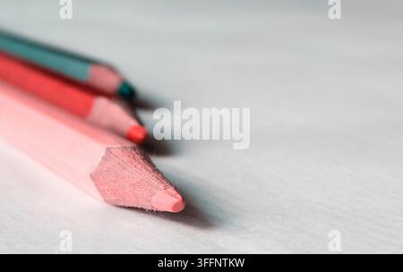 Three colorful wood drawing pencils on white table Stock Photo