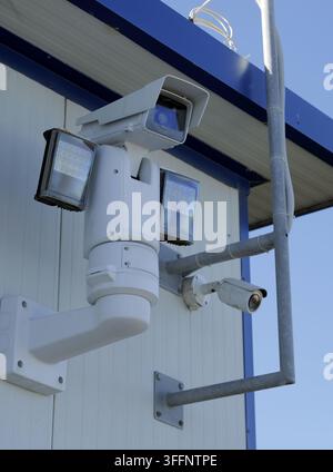 Modern surveillance setup with a rotating ptz camera with led floodlights and a fixed dome camera mounted on a building exterior. Providing comprehens Stock Photo