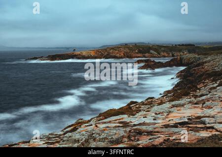 Coastal landscape with rocky shoreline against dramatic overcast skies Stock Photo