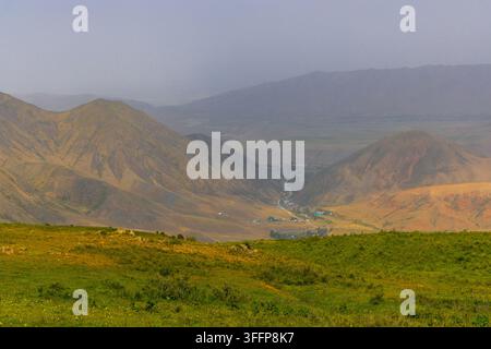 A wide-angle landscape features a winding river flowing through a lush ...