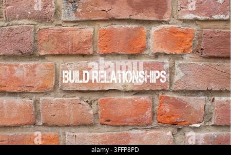 Build relationships text painted on brick wall. Trust and connection concept. Brick wall background. Copy space. Stock Photo