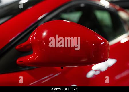 Milan, Italy - 12.11.2022: Red car side mirror closeup detail Stock Photo
