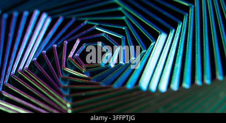 Abstract close-up of an iridescent geometric metal spiral, formed by layered hexagonal lines with vivid neon blue, green, and magenta reflections on a Stock Photo