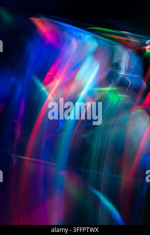 Vibrant abstract neon light trails sweep across a dark background, creating luminous blue, pink, green, and red streaks with a futuristic motion blur Stock Photo