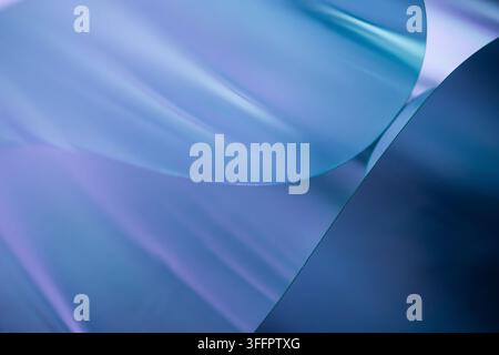 Abstract composition of translucent blue curved shapes layered over a soft purple gradient background, creating a calm modern design with smooth refle Stock Photo