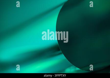 Abstract teal illumination casts soft diagonal shadows across a curved dark surface, creating a dramatic minimalist background with depth, contrast, a Stock Photo
