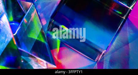 Vivid abstract close-up of faceted crystal prisms refracting neon blue, green, pink, and purple light into geometric reflections, creating a luminous Stock Photo