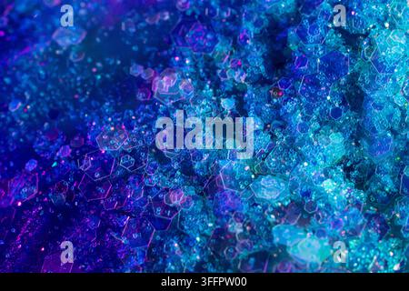 Vibrant abstract background with layered hexagonal shapes, glowing particles, and crystalline texture in luminous blue, cyan, violet, and purple tones Stock Photo