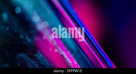 Abstract futuristic tech background featuring vivid neon pink and blue glowing lines across a dark textured surface, creating a dynamic cyberpunk atmo Stock Photo