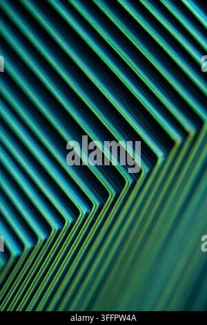 Close-up abstract pattern of glowing teal and blue diagonal lines forming sharp angular bends on a dark background, creating a futuristic geometric te Stock Photo