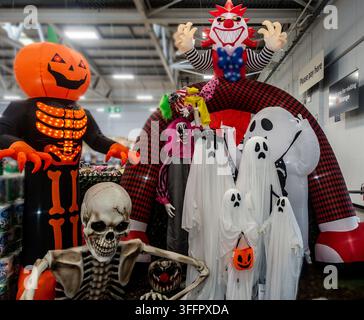 nflatable Halloween decorations display featuring ghosts, clown, and pumpkin skeleton at The Range store in Dublin, Ireland. Stock Photo