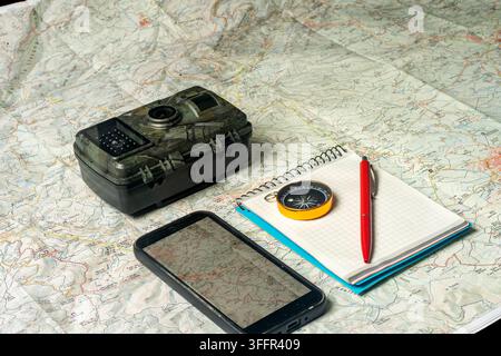 Outdoor navigation planning with trail camera, map, and smartphone Stock Photo