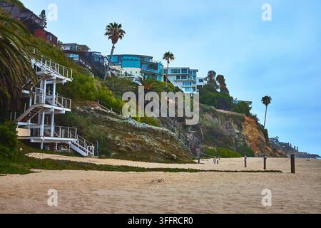 Laguna Beach Cliffside Homes Palm Trees and Sandy Shore at Thousand Steps Beach Stock Photo