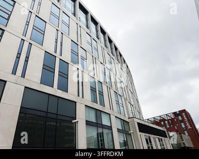 Liverpool, UK - May 16, 2026: Curved modern facade with reflective windows, concrete panels and John Lewis signage against cloudy sky. Stock Photo