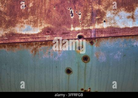 Rusty Abandoned Vehicle Texture with Bullet Holes and Faded Metal Surface Stock Photo