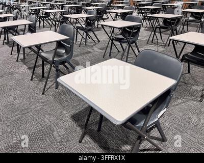 Empty chairs and tables in grey classroom. Stock Photo