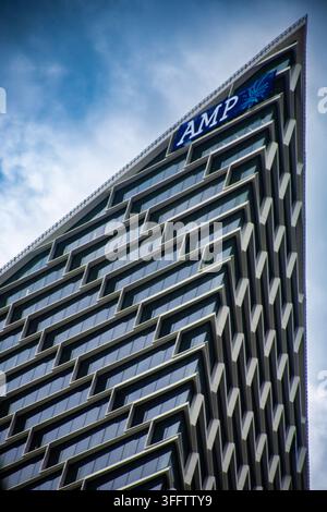 Tall modern high‑rise with sharp geometric design and reflective windows, against a partly cloudy sky. Stock Photo