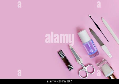 Manicure set and nail polish on side of pink background with copy space Stock Photo