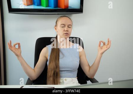 Young businesswoman finding calm and balance during a work break in the office Stock Photo