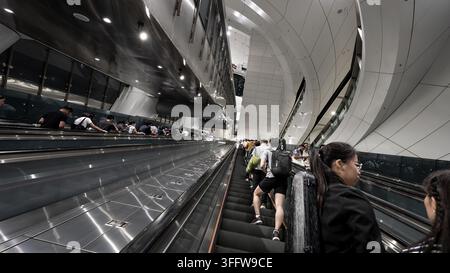 Passengers travelling on long escalators inside a modern MTR station in Hong Kong, China Stock Photo