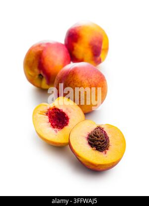 Ripe, juicy nectarines sliced in half with exposed pits arranged on a clean white background, highlighting texture, vibrant color and freshness for fo Stock Photo
