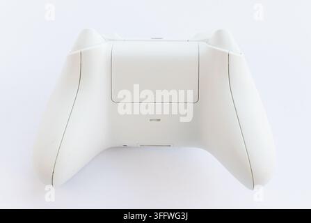 The rear side of a white gaming controller is shown Stock Photo