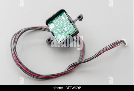 A small electronic module with wires and connector on grey background Stock Photo
