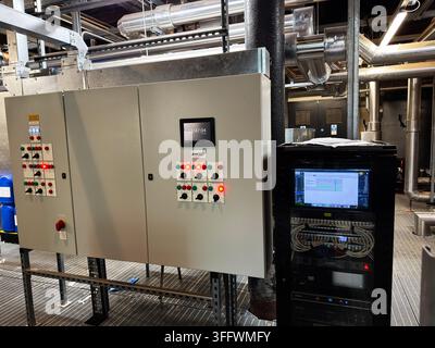 Manchester, UK - July 02, 2026: Industrial automation control panel and server rack with monitoring screen and organized cabling in Manchester plant r Stock Photo