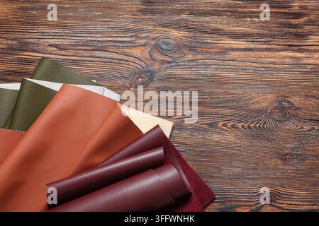 Leather craft and artisan design, colorful leather swatches and material samples on rustic wooden table for fashion manufacturing and upholstery proje Stock Photo
