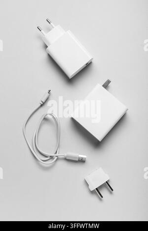 Technology connectivity and digital lifestyle, white power adapters and charging cables for mobile devices on a clean neutral background Stock Photo