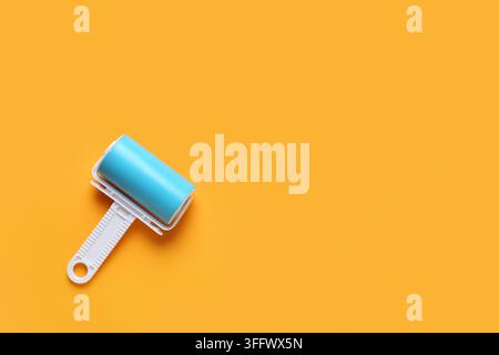 Lint roller on orange background Stock Photo