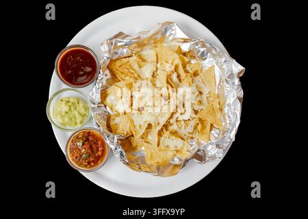 Nachos with melted cheese, guacamole, salsa, and dips Stock Photo