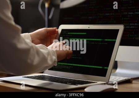Female programmers hands working with laptop in office at night, closeup Stock Photo