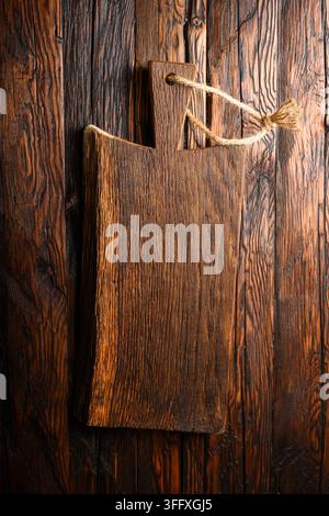 Small knife with wooden handle lying on an old cutting board on rusty aged table Stock Photo