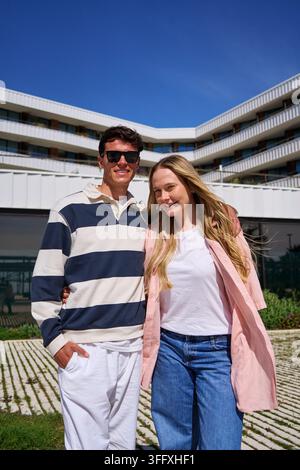Happy young couple posing at modern hotel building Stock Photo