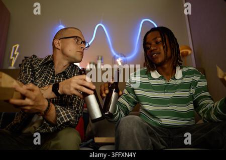Diverse Friends Drinking Beer at Home Stock Photo