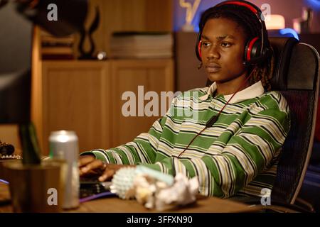 Black Man with Headset Playing Video Games at Computer Stock Photo
