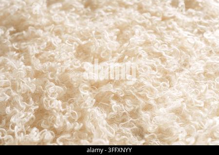 Cream curly faux fur texture background with soft fluffy surface Stock Photo