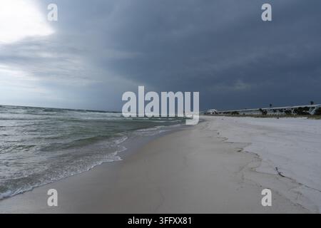 Dark storm clouds gathering over a sandy beach and rough coastal water. Dramatic seaside landscape suitable for storm, changing weather, weather warni Stock Photo