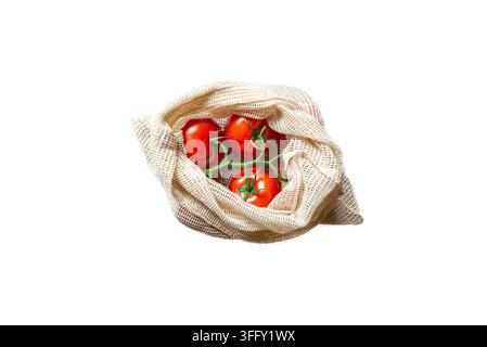 Cut out of Fresh ripe tomatoes on a vine inside an eco-friendly reusable mesh bag on white isolated transparent background. Stock Photo