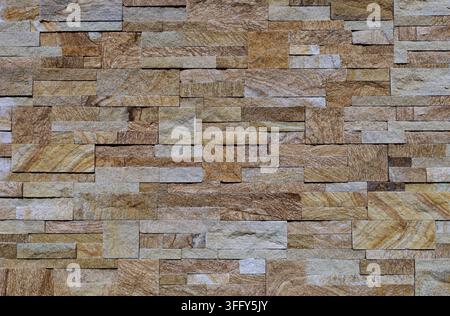 Elegant external or internal wall covering made of bricks and cubes of stoneware with multicolored stone effect. Background and texture. Stock Photo