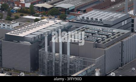Aerial view of a large data center with multiple cooling units on the roof, tall ventilation chimneys, and metal facade structures in Frankfurt am Mai Stock Photo